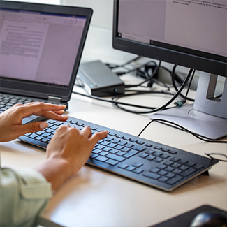 Hands typing on a keyboard