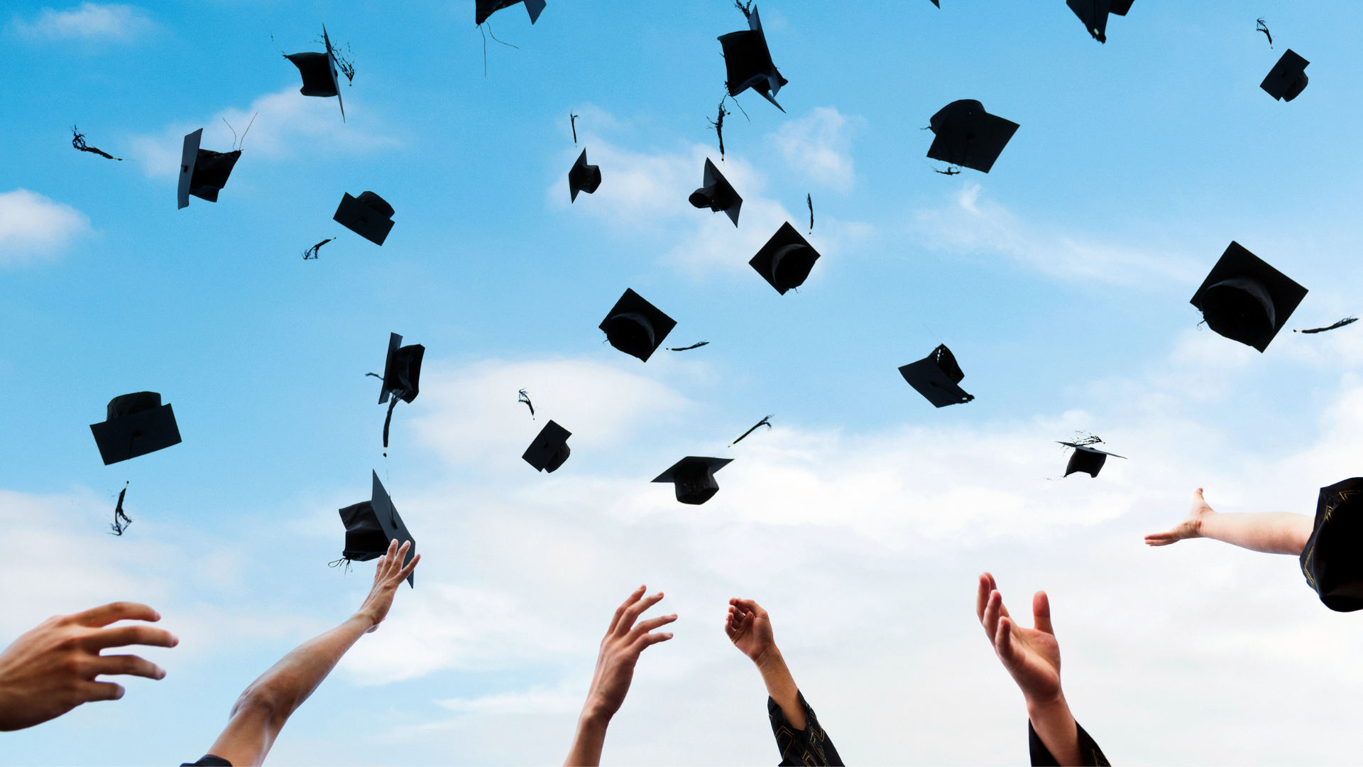 graduation caps being thrown in the air