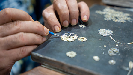 Hands working on a small piece of jewelry