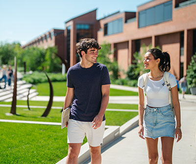 Male and female student walk on path at Newtown Campus