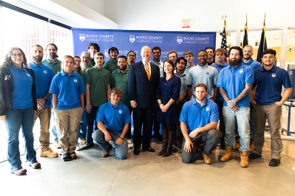 People posed for a photograph in front of BCCC signage