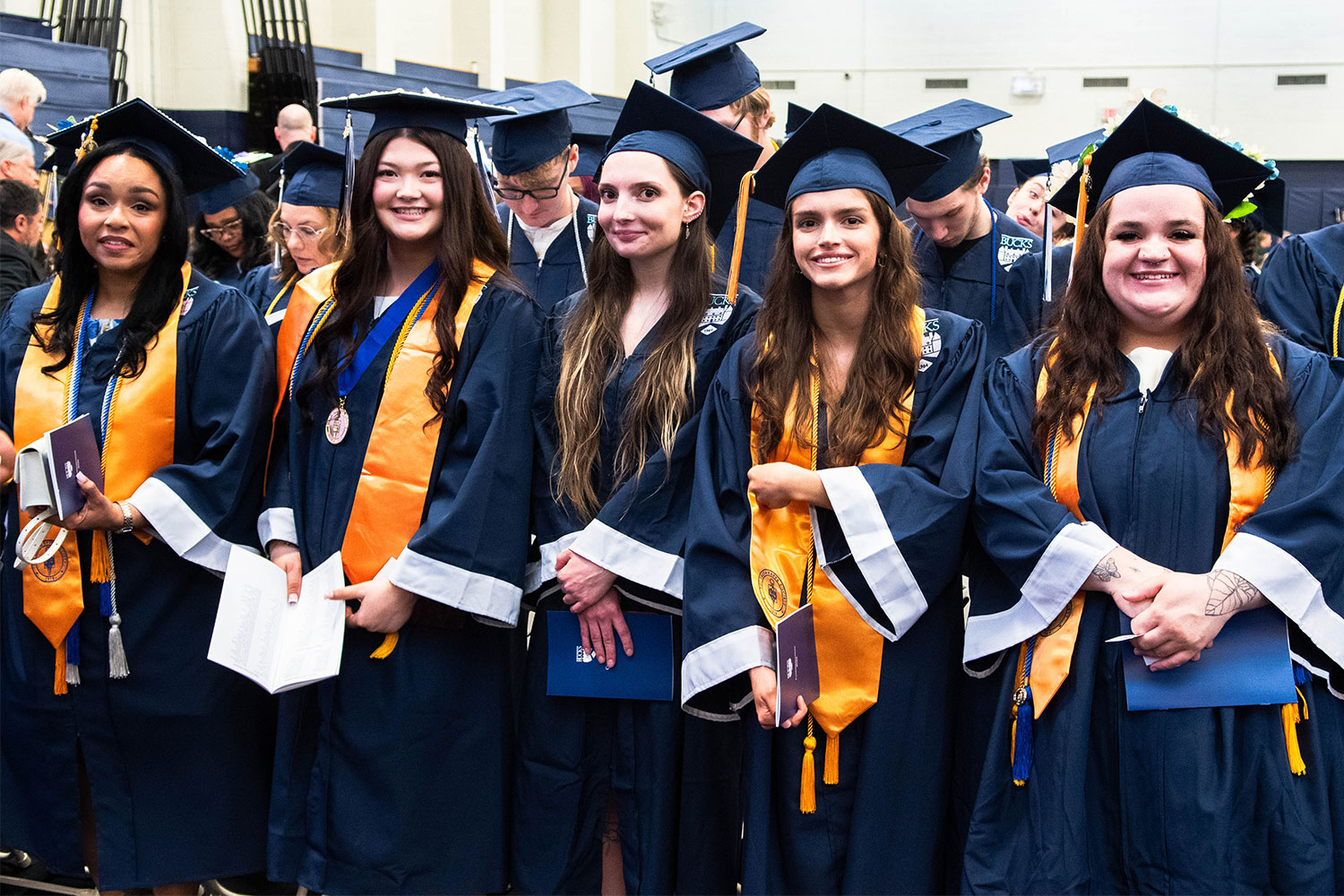 Honors at Bucks graduates in cap and gown with yellow stole